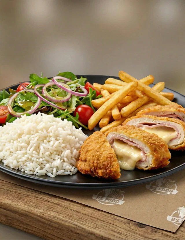 Assiette de cordon bleu au fromage avec frites, riz et salade verte, posée sur une planche en bois